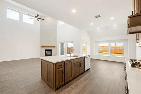 a view of a kitchen counter space a sink wooden floor and windows
