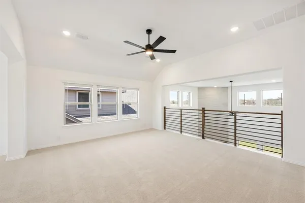 en empty room with windows and ceiling fan