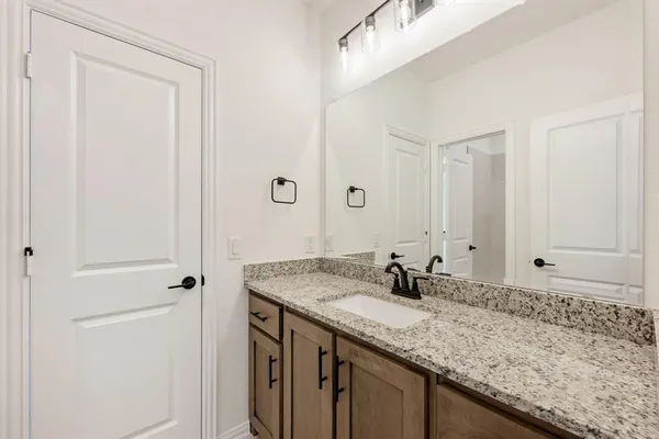 a bathroom with a granite countertop sink and a mirror