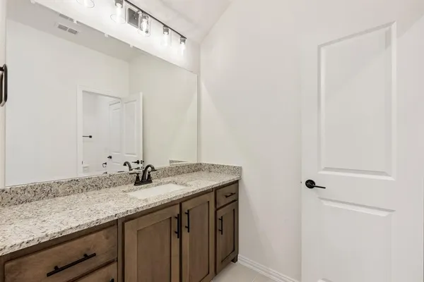 a bathroom with a granite countertop sink and a mirror