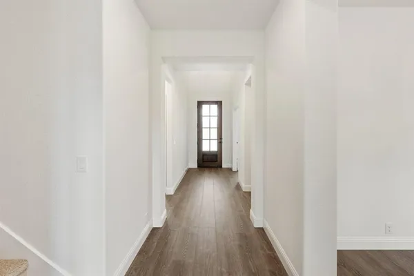 a view of a hallway with wooden floor