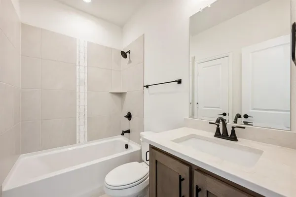 a bathroom with a granite countertop sink a toilet and shower