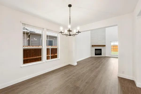 a view of a livingroom with a fireplace wooden floor and a chandelier
