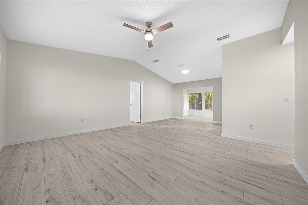 7556 Southwest 112th Lane Ocala, FL 34476 - Photo 16 of 37 an empty room with wooden floor ceiling fan and window