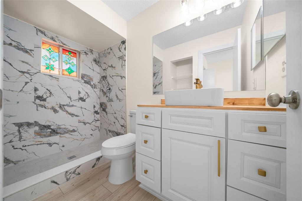 7556 Southwest 112th Lane Ocala, FL 34476 - Photo 21 of 37 a bathroom with a sink a toilet and a shower curtain