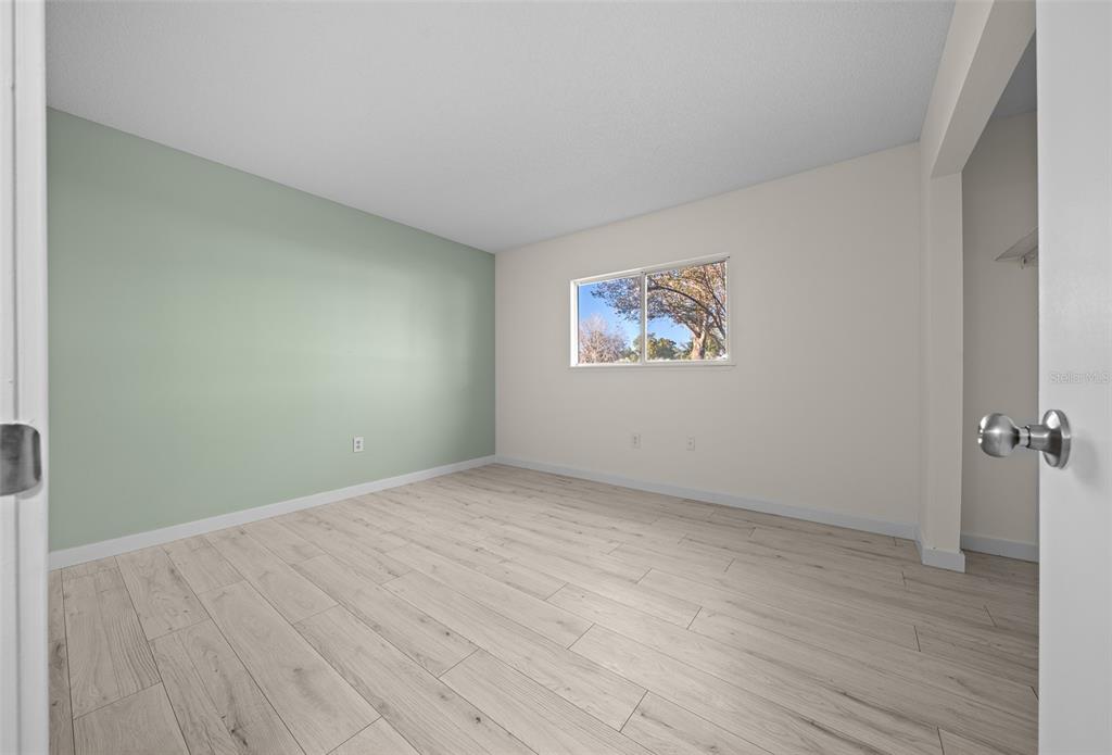 7556 Southwest 112th Lane Ocala, FL 34476 - Photo 22 of 37 an empty room with wooden floor and windows