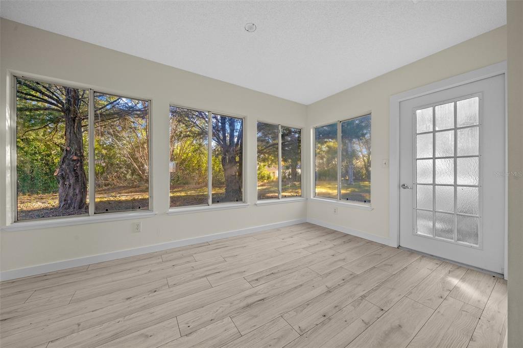 7556 Southwest 112th Lane Ocala, FL 34476 - Photo 26 of 37 a view of an empty room with a window and wooden floor