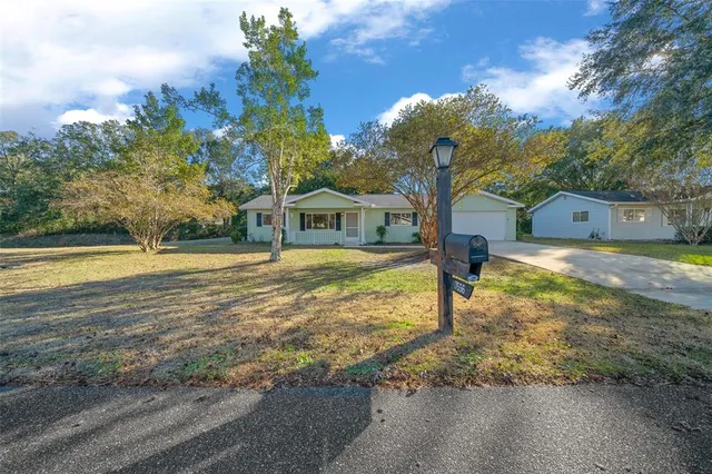 a front view of a house with yard and green space