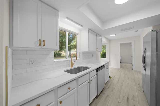 a kitchen with granite countertop a sink and cabinets