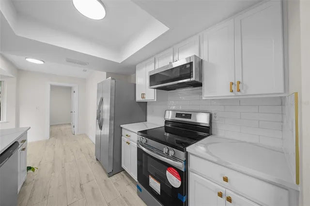 a kitchen with a sink a stove and cabinets