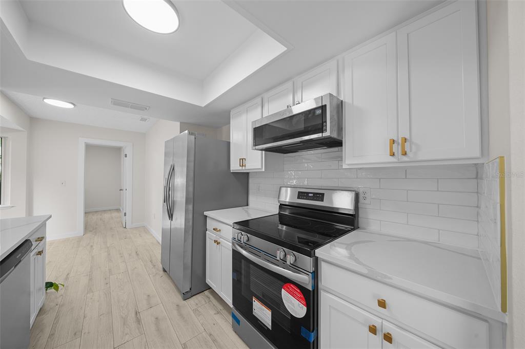 7556 Southwest 112th Lane Ocala, FL 34476 - Photo 5 of 37 a kitchen with a sink a stove and cabinets