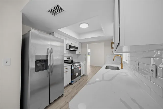 a kitchen with stainless steel appliances a refrigerator and a sink