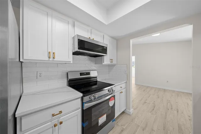 a kitchen with stainless steel appliances a stove a microwave and cabinets