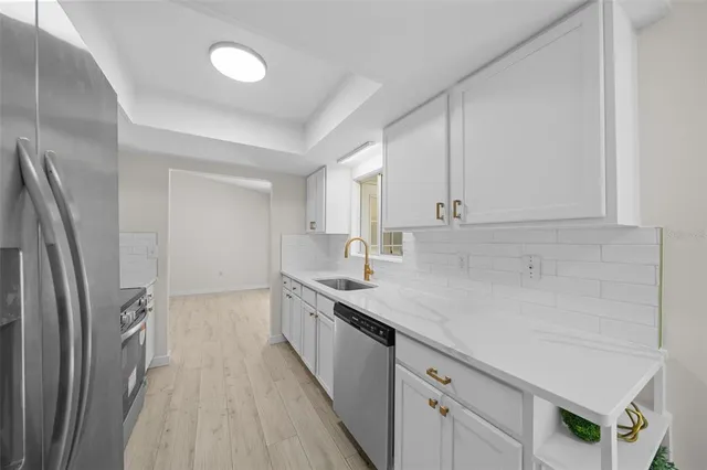 a kitchen with stainless steel appliances a sink stove and refrigerator