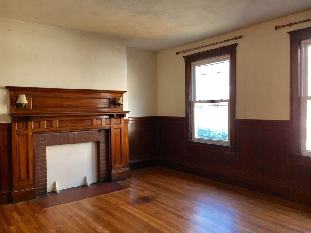 20 St Lukes Road, Unit 1 Boston, MA 02134 - Photo 3 of 10 a view of a livingroom with wooden floor and a fireplace