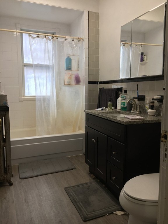 20 St Lukes Road, Unit 1 Boston, MA 02134 - Photo 4 of 10 a bathroom with a granite countertop sink toilet a large mirror and shower