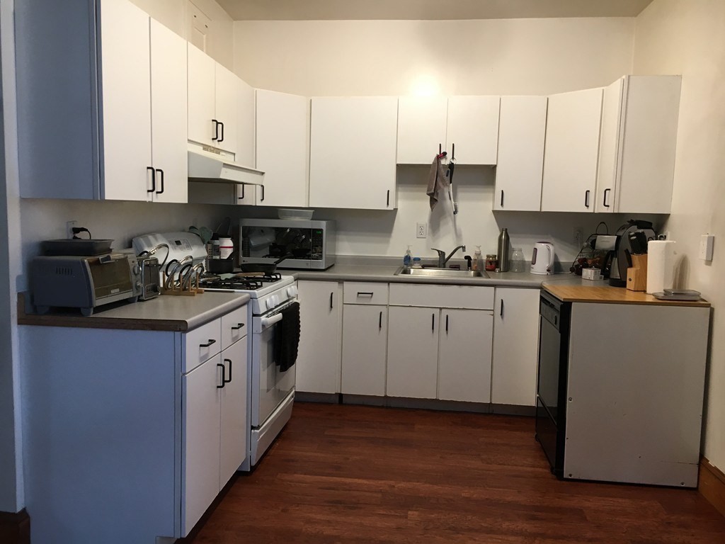 20 St Lukes Road, Unit 1 Boston, MA 02134 - Photo 7 of 10 a kitchen with stainless steel appliances white cabinets sink and stove