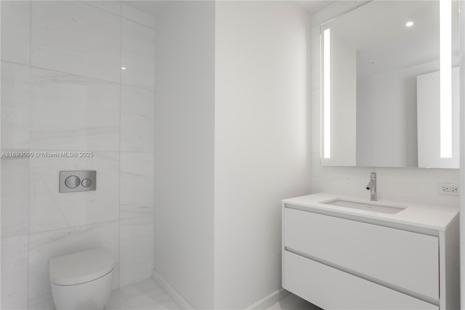 300 Biscayne Blvd Way, Unit 3307 Miami, FL 33131 - Photo 33 of 59 a bathroom with a sink a toilet and a mirror