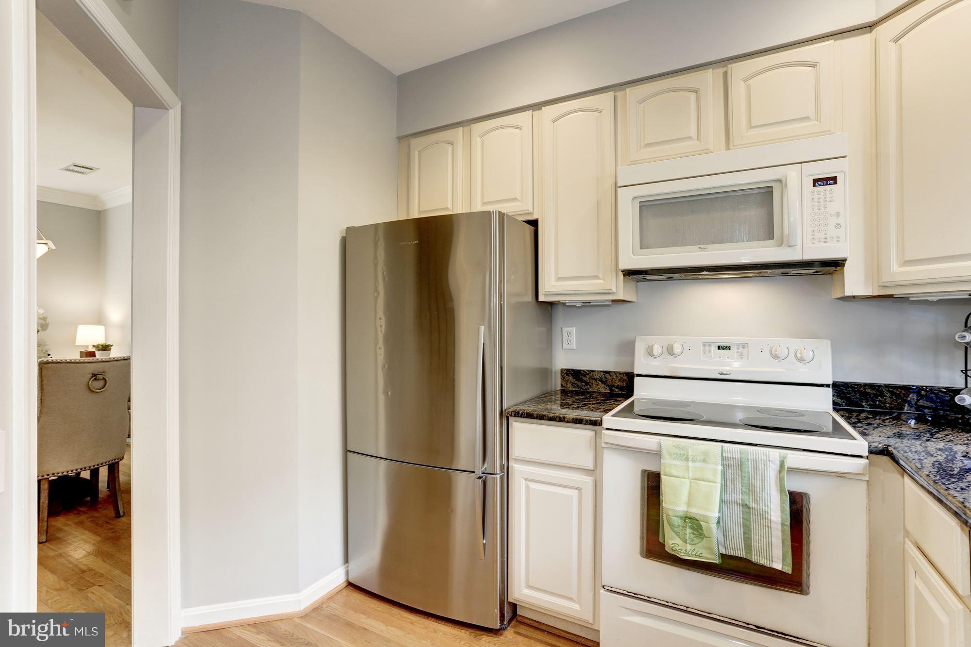 1221 Portner Road Alexandria, VA 22314 - Photo 6 of 30 a kitchen with white cabinets and stainless steel appliances
