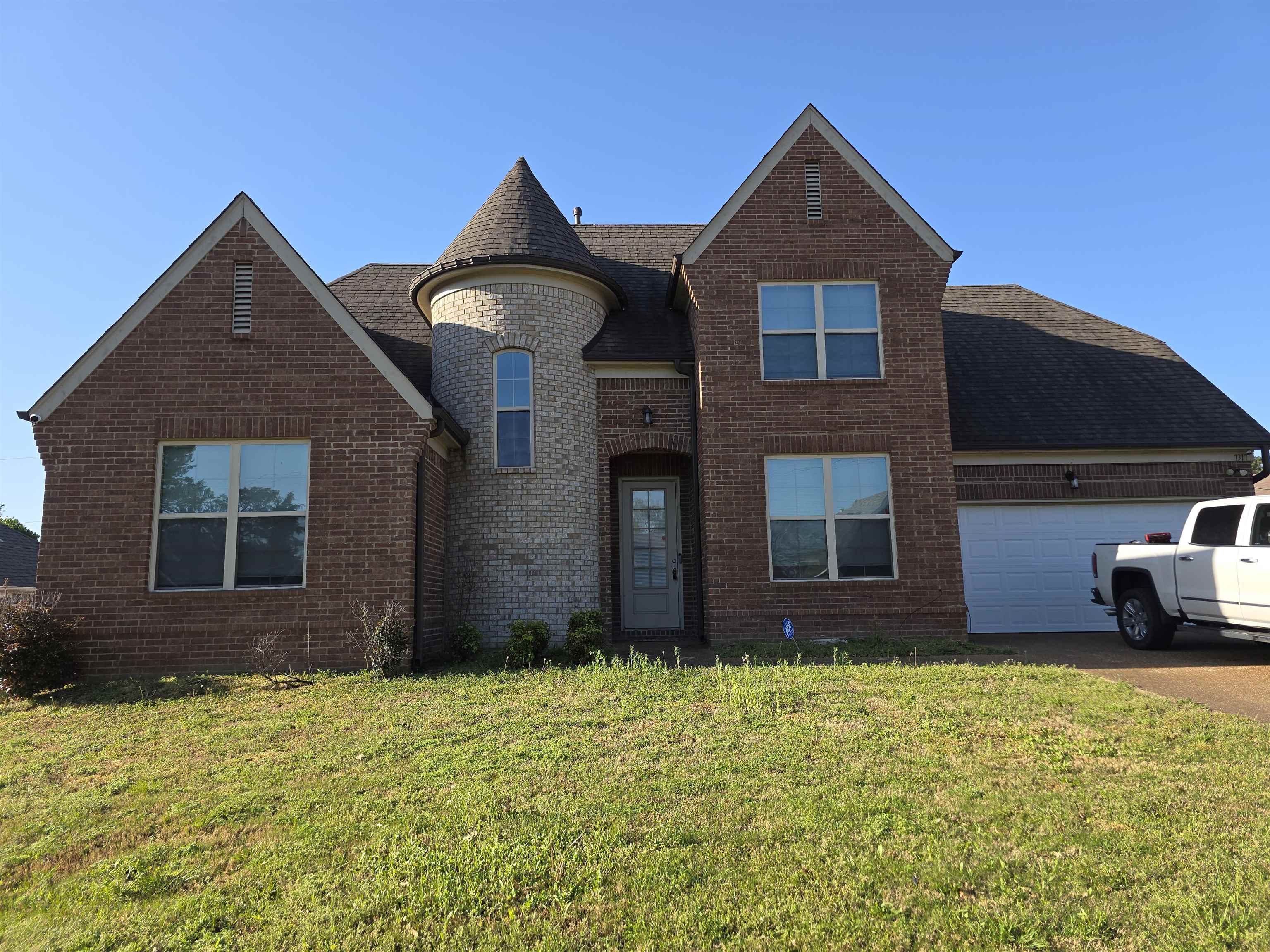 7317 Patsy Circle North Memphis, TN 38125 - Photo 1 of 26 View of front facade featuring brick siding, an attached garage, a front yard, and driveway