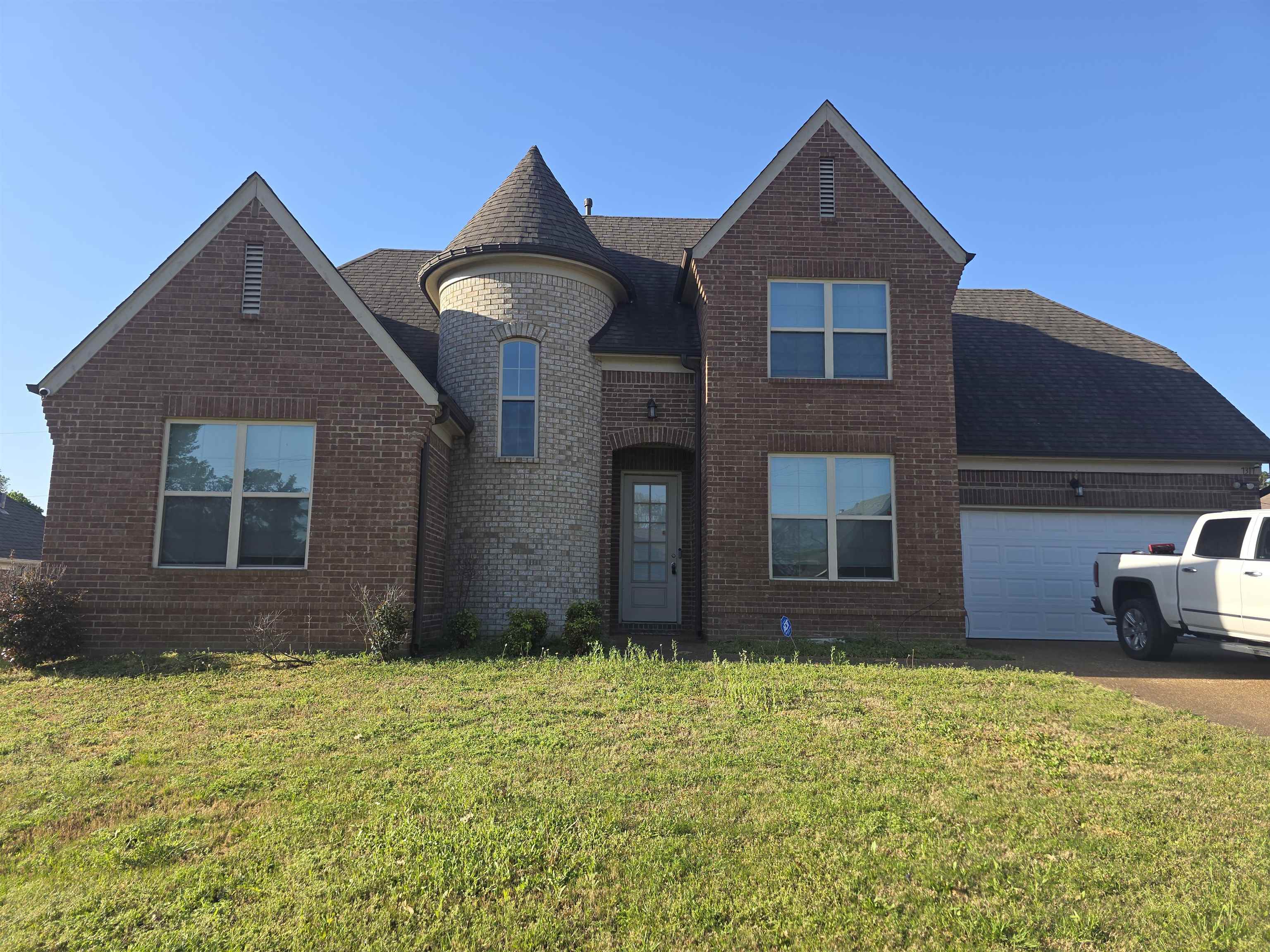 7317 Patsy Circle North Memphis, TN 38125 - Photo 2 of 26 View of front of home with concrete driveway, brick siding, an attached garage, a shingled roof, and a front yard