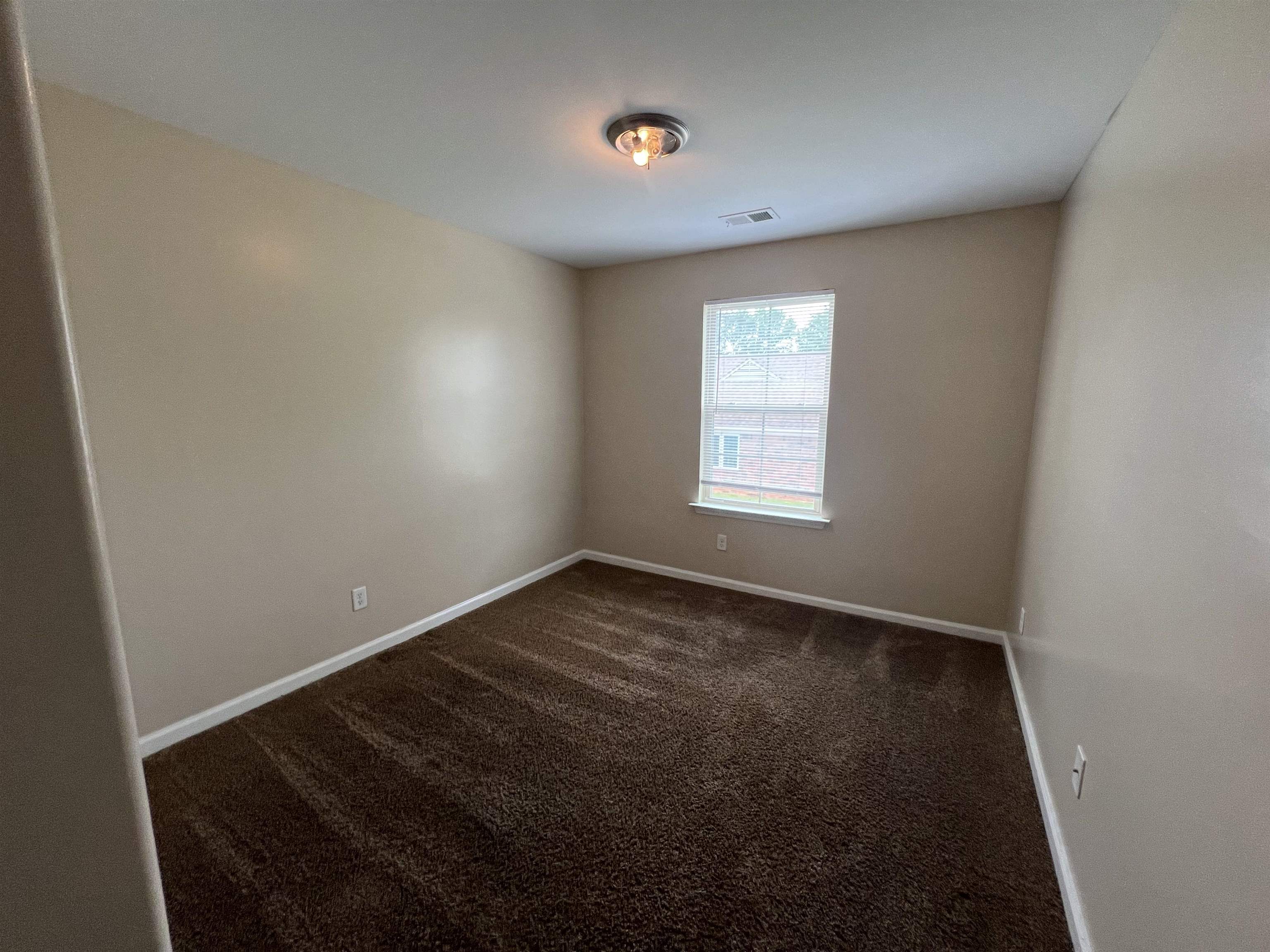 7317 Patsy Circle North Memphis, TN 38125 - Photo 21 of 26 Spare room featuring baseboards, visible vents, and dark carpet