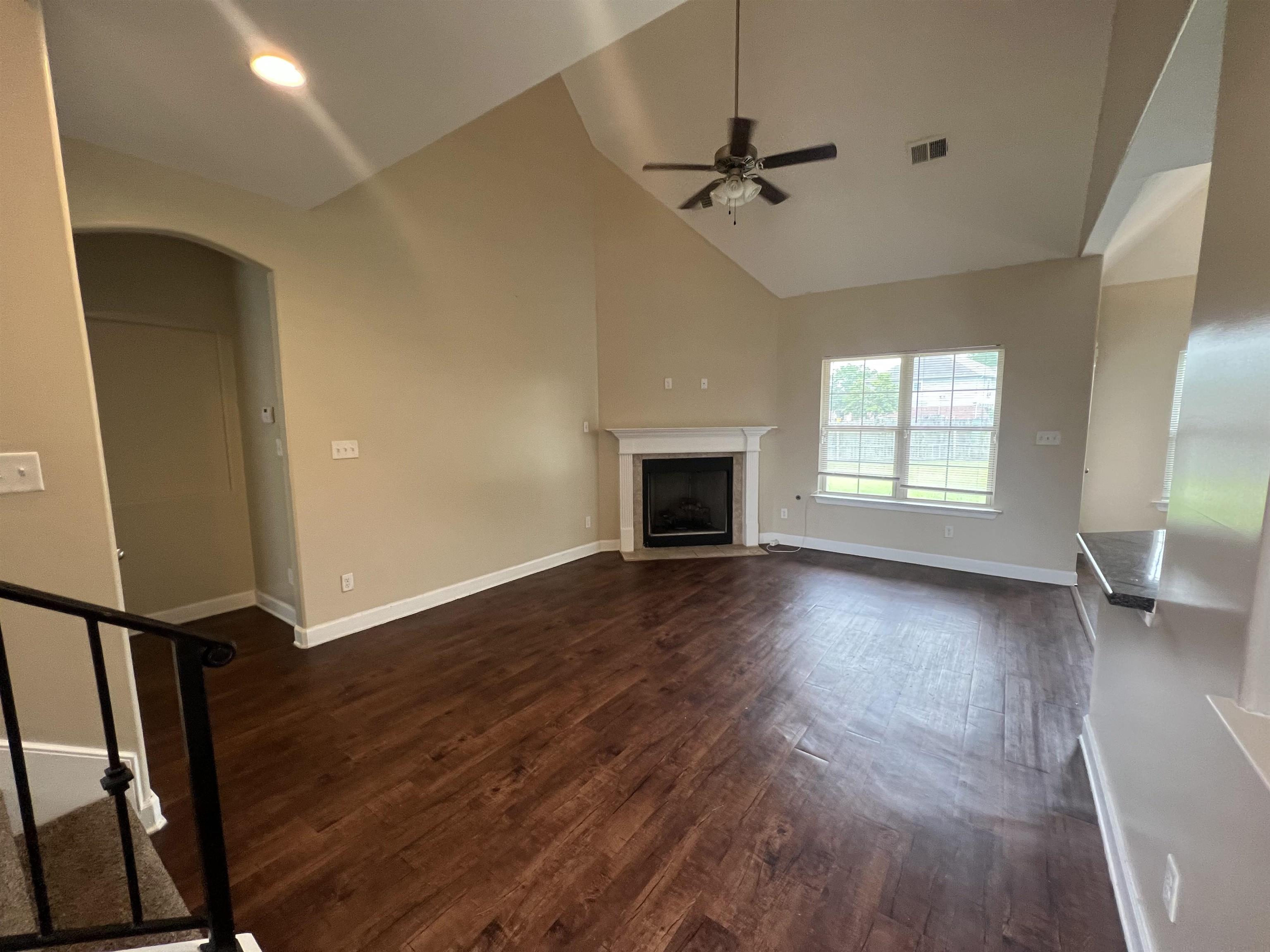 7317 Patsy Circle North Memphis, TN 38125 - Photo 3 of 26 Unfurnished living room with ceiling fan, high vaulted ceiling, dark wood finished floors, baseboards, and a fireplace with flush hearth