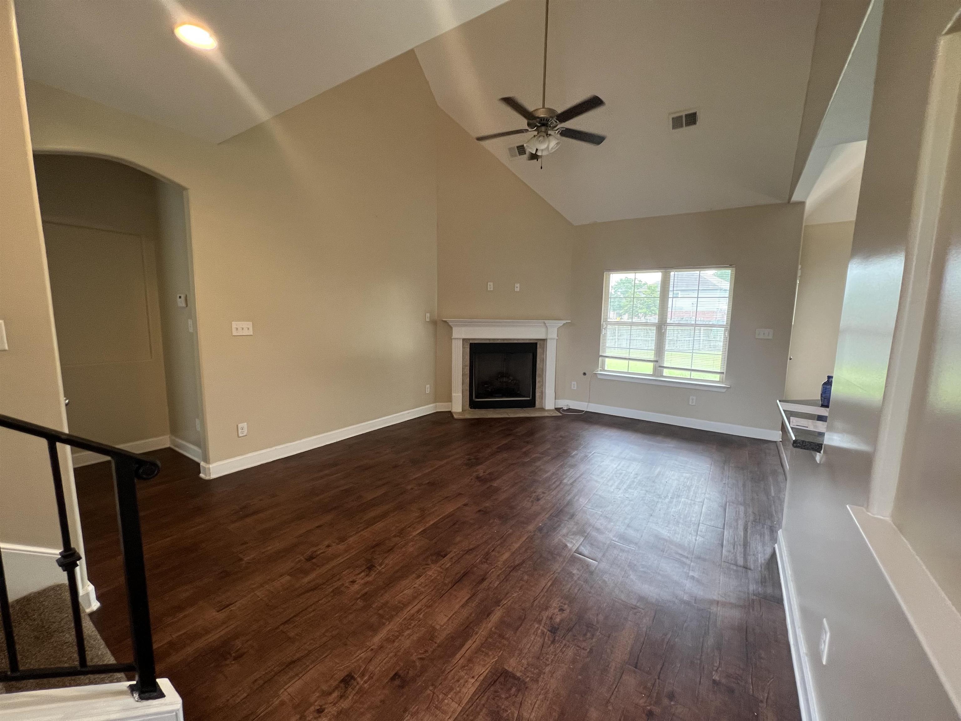 7317 Patsy Circle North Memphis, TN 38125 - Photo 5 of 26 Unfurnished living room with arched walkways, high vaulted ceiling, a ceiling fan, dark wood-type flooring, and visible vents