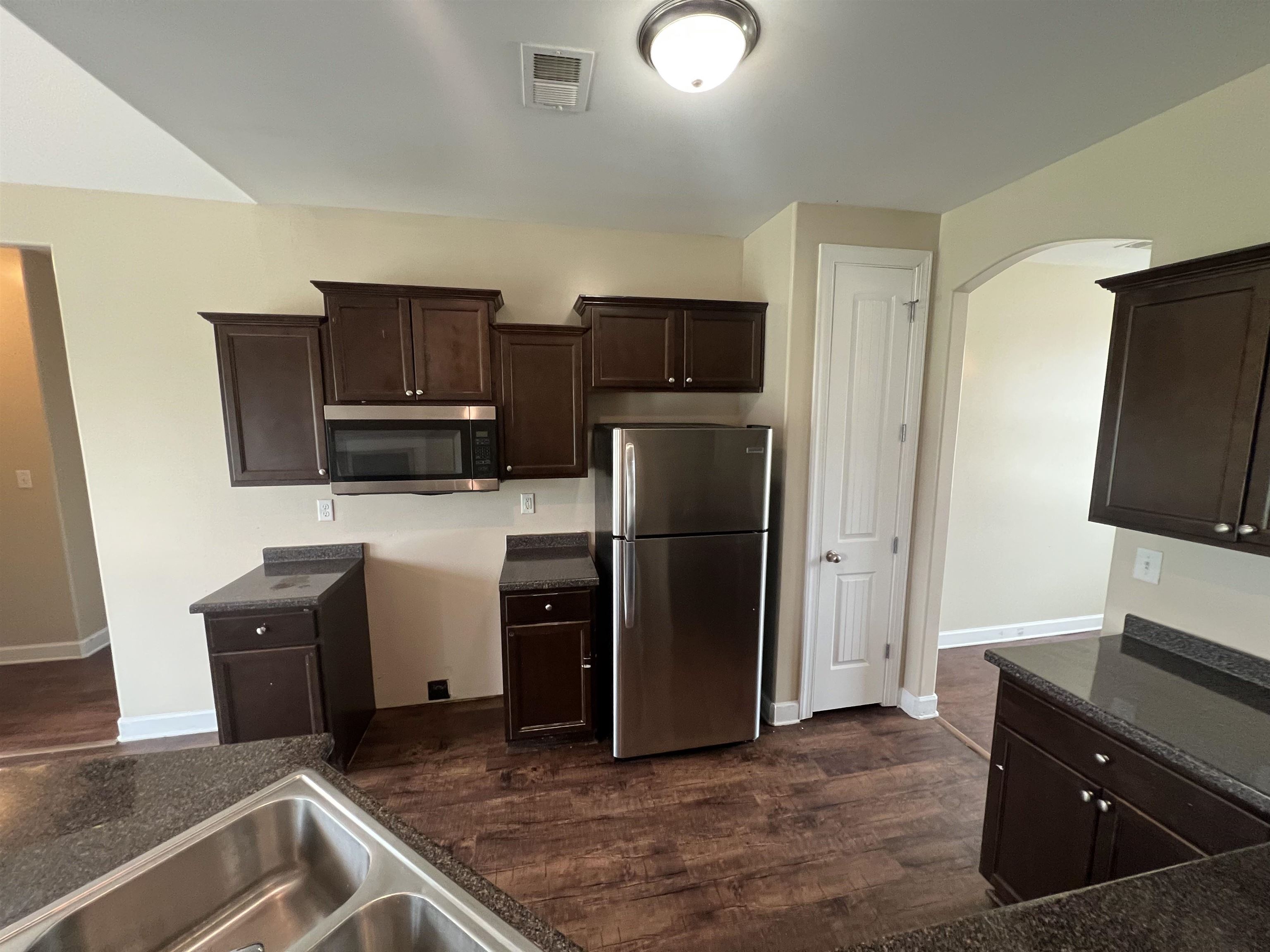 7317 Patsy Circle North Memphis, TN 38125 - Photo 9 of 26 Kitchen featuring visible vents, dark brown cabinetry, baseboards, arched walkways, and appliances with stainless steel finishes