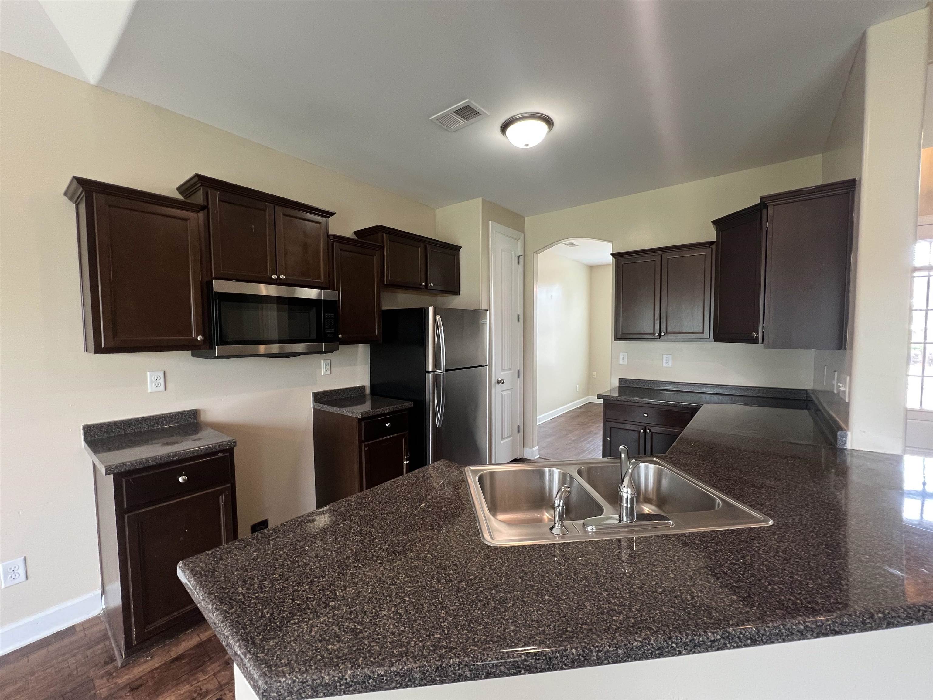7317 Patsy Circle North Memphis, TN 38125 - Photo 10 of 26 Kitchen featuring visible vents, dark brown cabinets, arched walkways, a sink, and stainless steel appliances