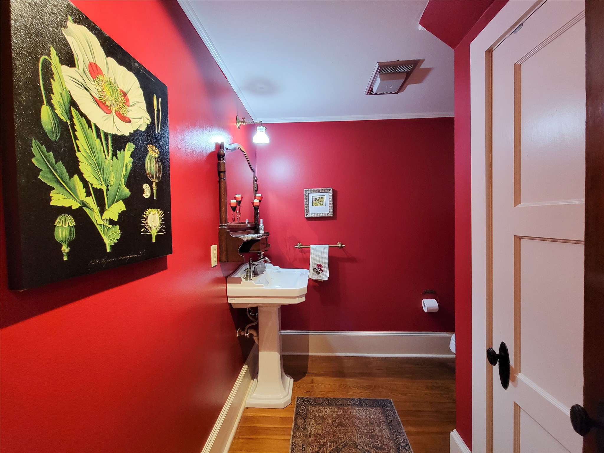 1406 Key Street Brenham, TX 77833 - Photo 10 of 50 The hall entry boasts elegant built-in cabinets with leaded glass doors and a stylishly decorated half bath featuring a pedestal sink.