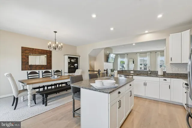 a large white kitchen with a table and chairs