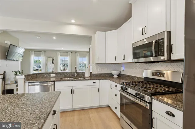 a kitchen with stainless steel appliances granite countertop a stove and a microwave