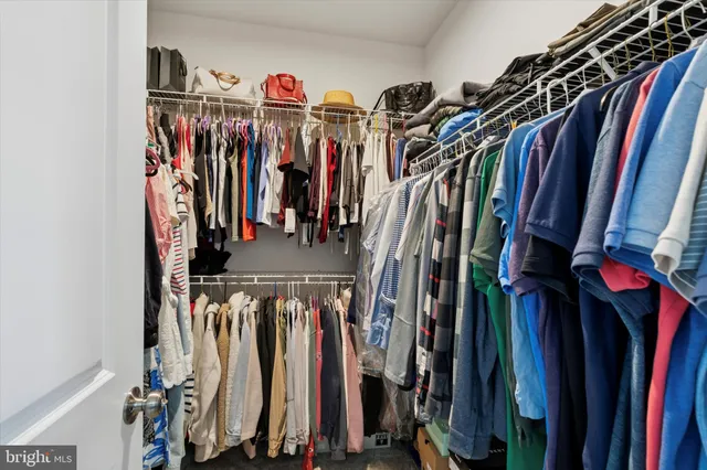 a view of walk in closet with clothes