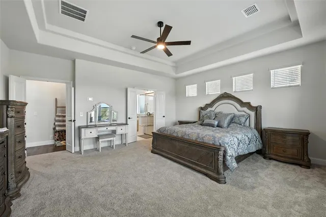a spacious bedroom with a bed and a chandelier