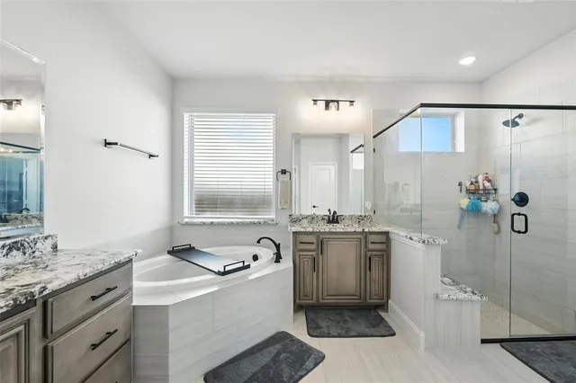 a bathroom with a granite countertop sink a toilet a mirror and shower