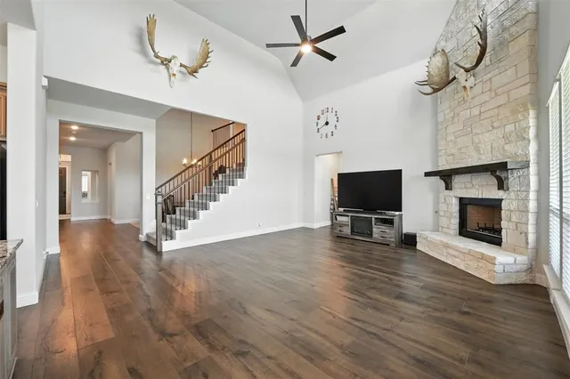 a view of a livingroom with wooden floor a flat screen tv and a fireplace