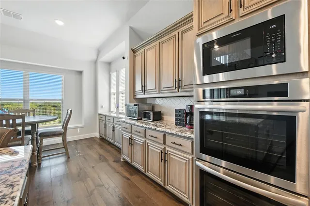 a kitchen with stainless steel appliances a stove a microwave and cabinets