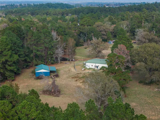 a view of a field with an tree and a wooden fence