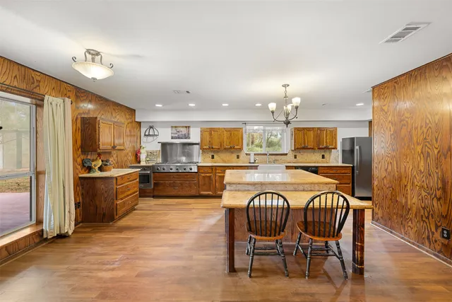 a kitchen with granite countertop a sink a counter top space stainless steel appliances and cabinets