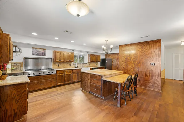 a view of a livingroom with a chandelier fan and windows