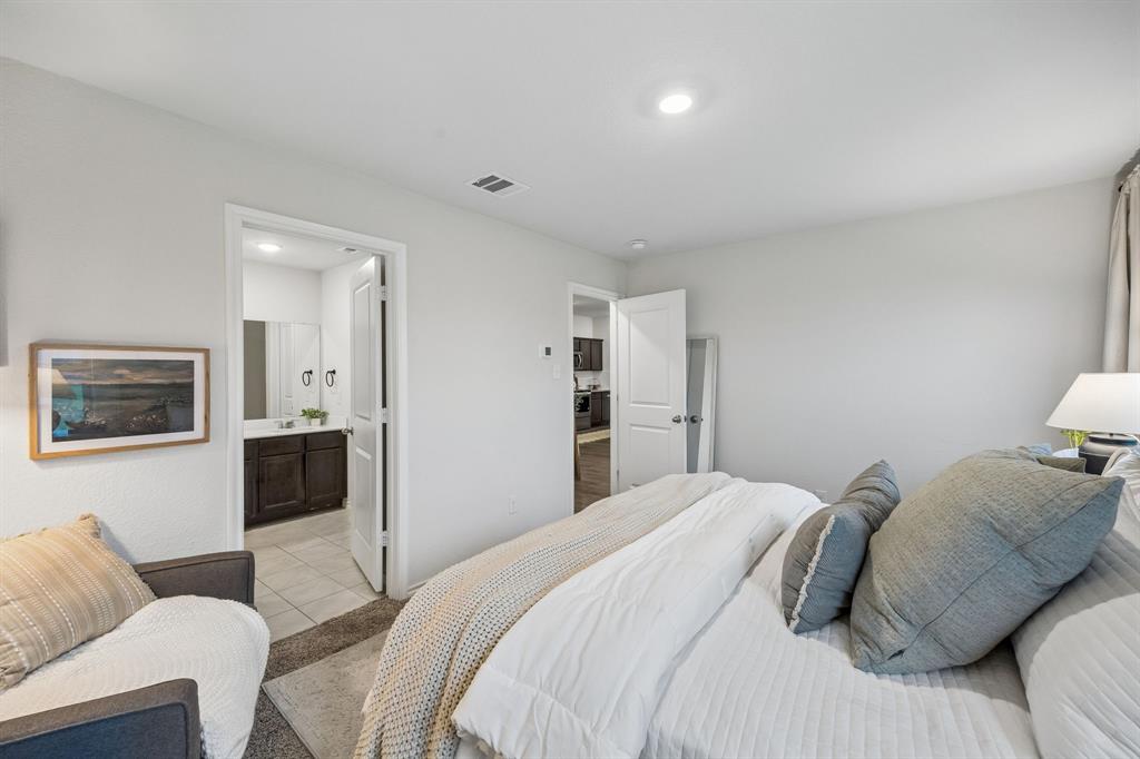 1107 Ringgold Road Forney, TX 75126 - Photo 17 of 27 Primary bedroom featuring light-colored walls, recessed lighting, and a doorway to a bathroom with a dark wood-finish vanity
