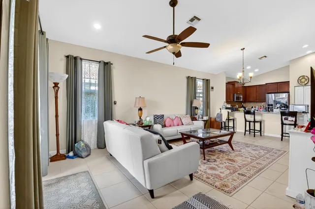 a living room with furniture and a view of kitchen