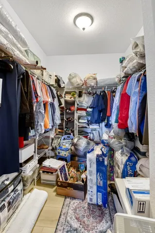 a view of walk in closet with clothes and shoes