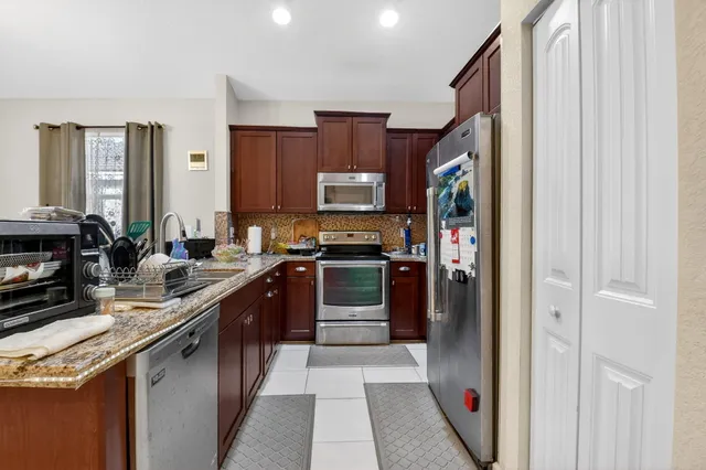 a kitchen with stainless steel appliances granite countertop a stove and a refrigerator