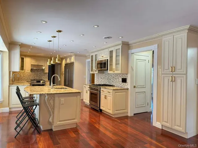 a large kitchen with stainless steel appliances granite countertop a stove and a refrigerator