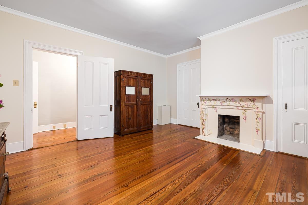 515 Polk Street Raleigh, NC 27604 - Photo 16 of 25 an empty room with wooden floor and fireplace