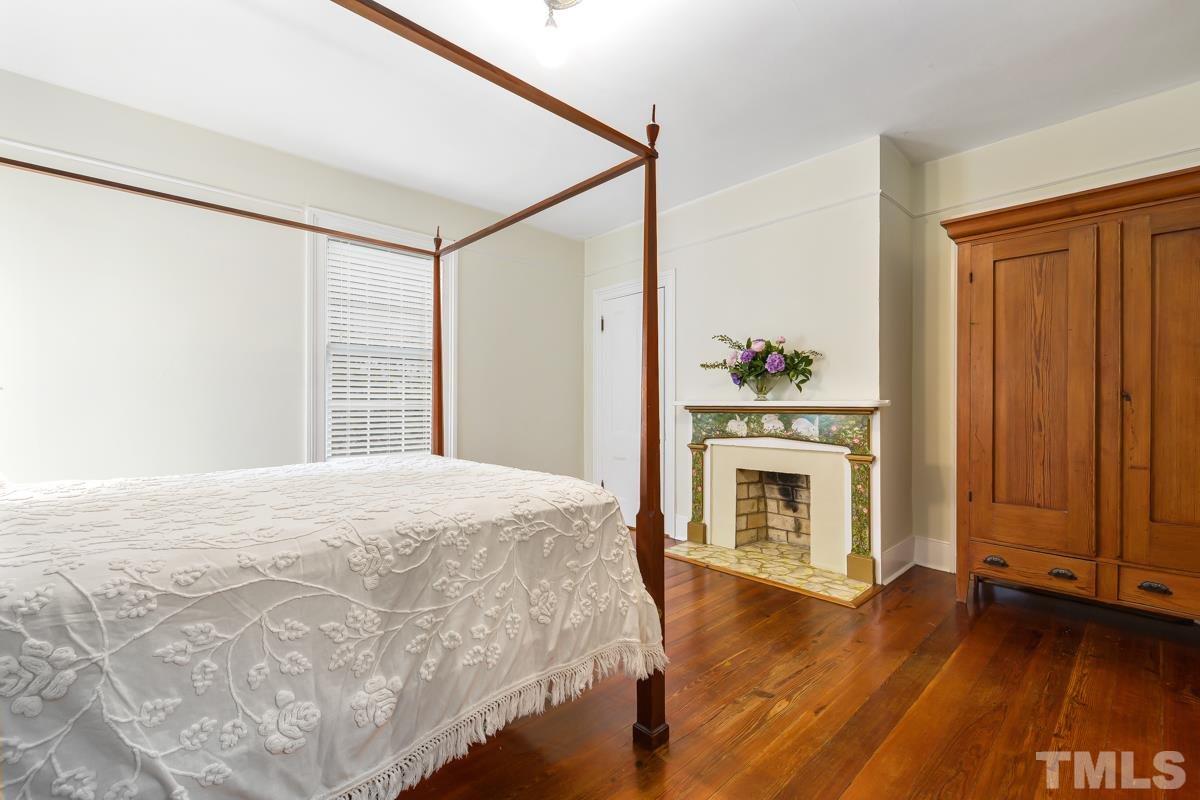 515 Polk Street Raleigh, NC 27604 - Photo 19 of 25 a bedroom with a bed and a fireplace