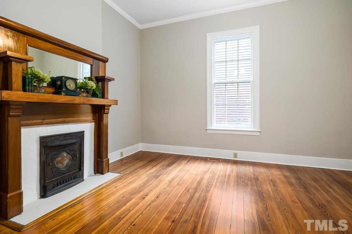 515 Polk Street Raleigh, NC 27604 - Photo 6 of 25 a view of an empty room with wooden floor fireplace and a window