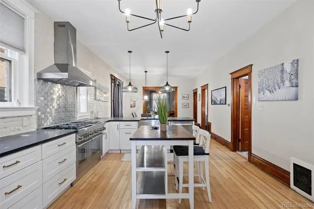 a kitchen with granite countertop cabinets a dining table and appliances
